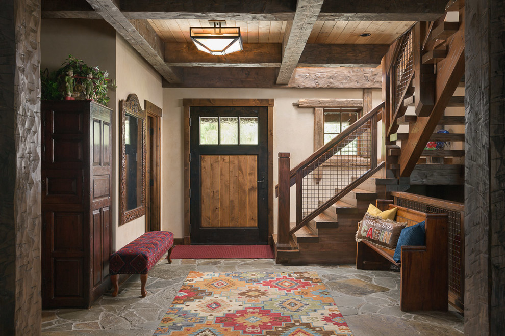 Example of a mid-sized mountain style slate floor and gray floor single front door design in Jackson with beige walls and a medium wood front door