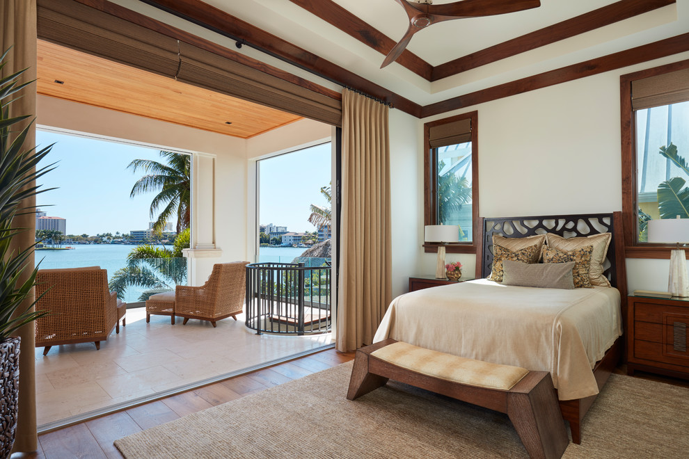 Inspiration for a mid-sized tropical master bedroom in Miami with white walls, dark hardwood floors, no fireplace and brown floor.