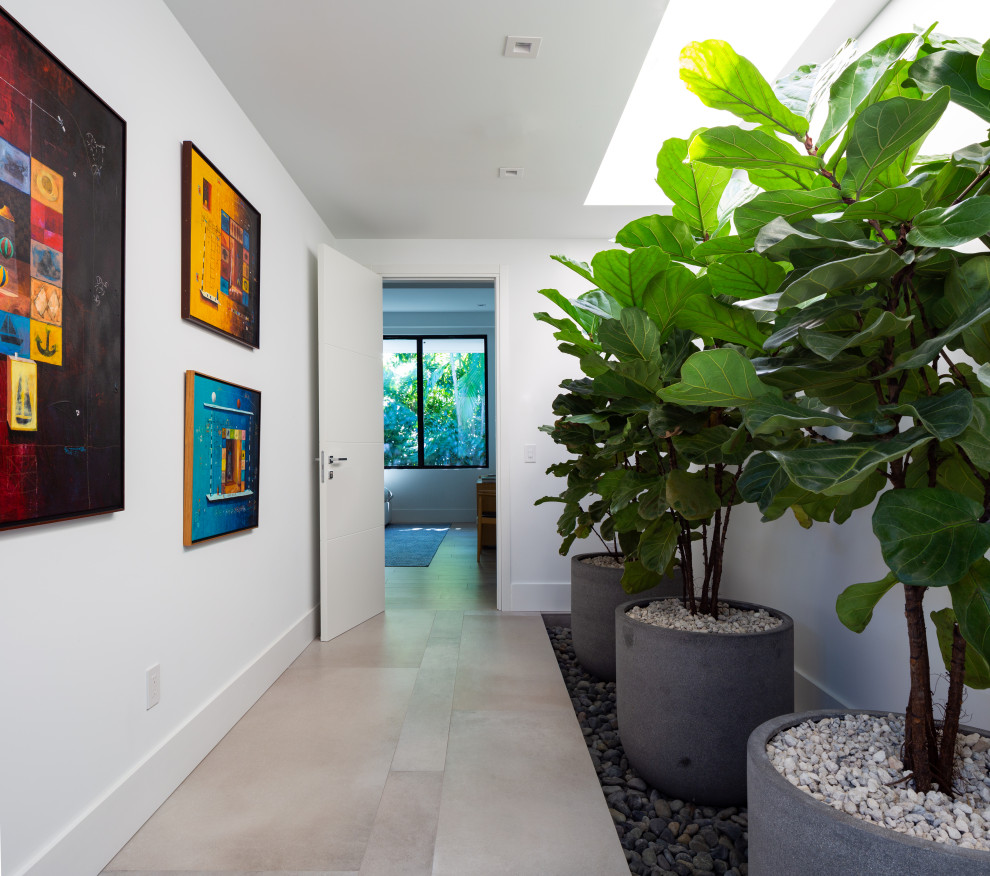 Example of a large trendy porcelain tile, gray floor and wallpaper ceiling hallway design in Miami with white walls