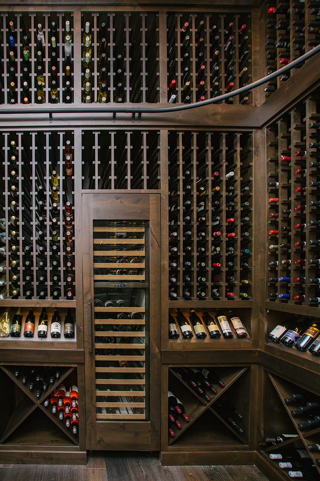 Photo of a mid-sized transitional wine cellar in Portland with dark hardwood floors, storage racks and brown floor.