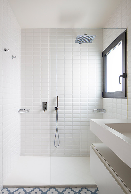 Inspiration for a large modern master wet room bathroom in Valencia with flat-panel cabinets, white cabinets, a one-piece toilet, white tile, ceramic tile, white walls, ceramic floors, a trough sink, multi-coloured floor and white benchtops.