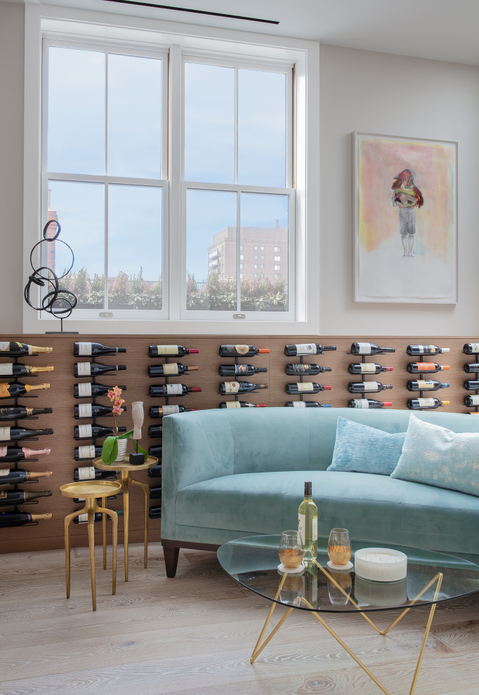 Large contemporary wine cellar in Boston with light hardwood flooring, display racks and beige floors.