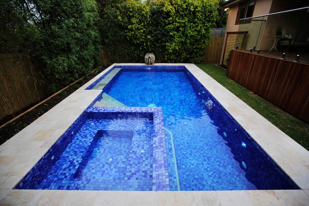 Photo of a mid-sized contemporary backyard custom-shaped lap pool in Melbourne with a hot tub and natural stone pavers.