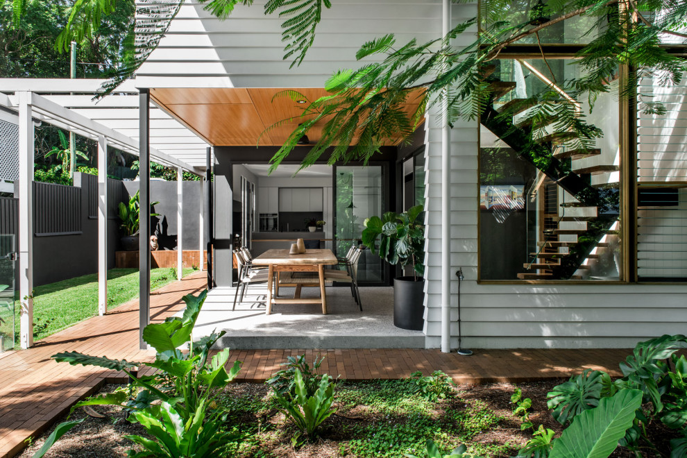 Mid-sized traditional two-storey white house exterior in Brisbane with concrete fiberboard siding, a gable roof and a metal roof.