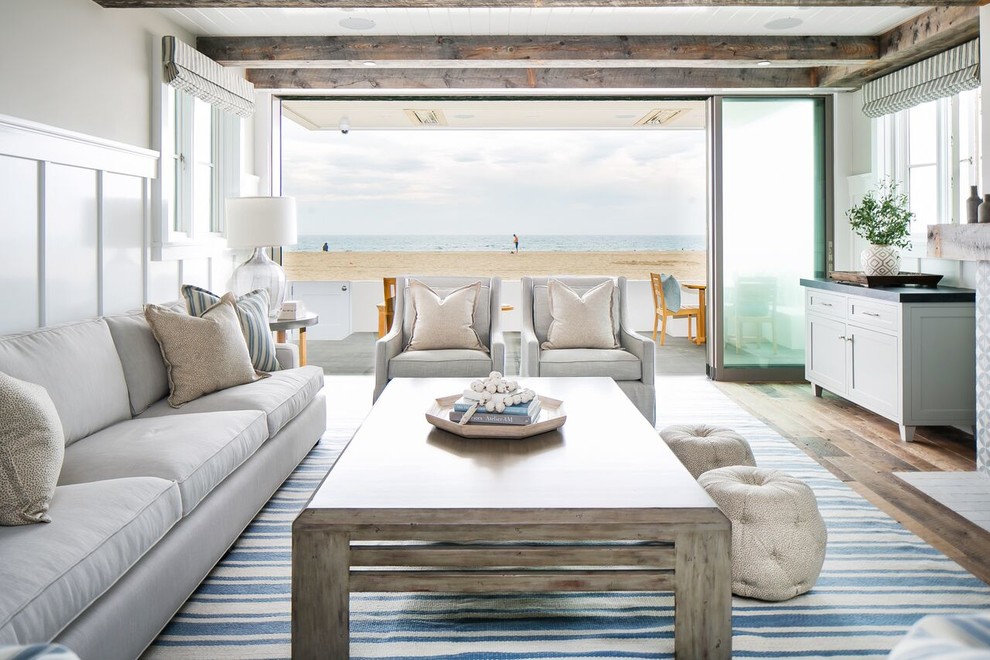 Inspiration for a mid-sized beach style open concept family room in Orange County with white walls, dark hardwood floors, a standard fireplace, a tile fireplace surround, a wall-mounted tv and brown floor.