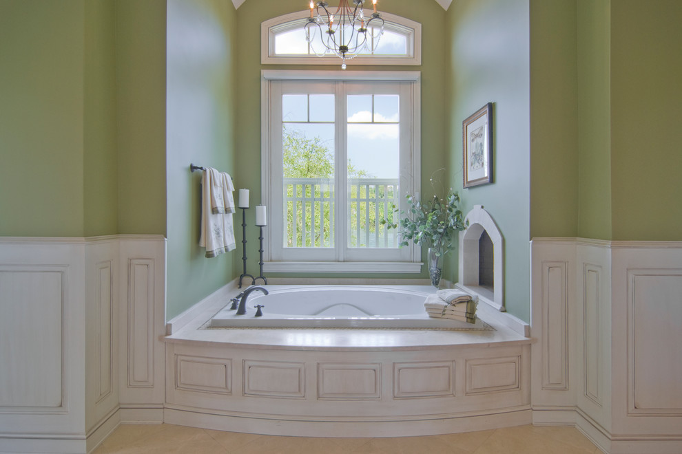 Inspiration for a traditional bathroom in New York with raised-panel cabinets, white cabinets, marble benchtops, a drop-in tub, green walls and marble floors.