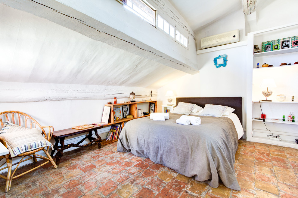 Design ideas for a mid-sized country master bedroom in Marseille with white walls and terra-cotta floors.