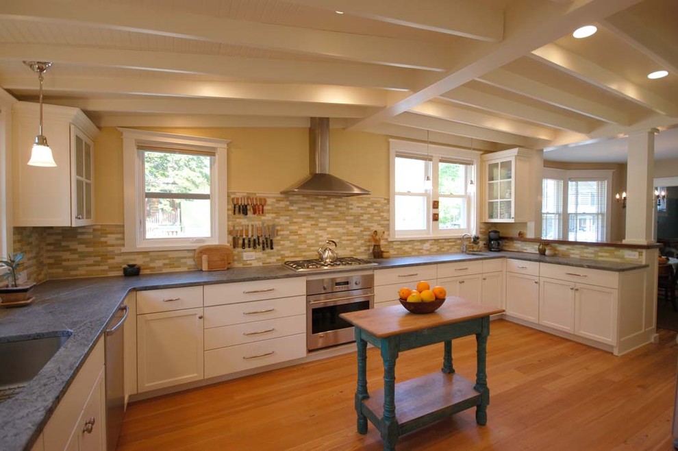 Country u-shaped eat-in kitchen in Philadelphia with an undermount sink, recessed-panel cabinets, white cabinets, granite benchtops, orange splashback and stainless steel appliances.