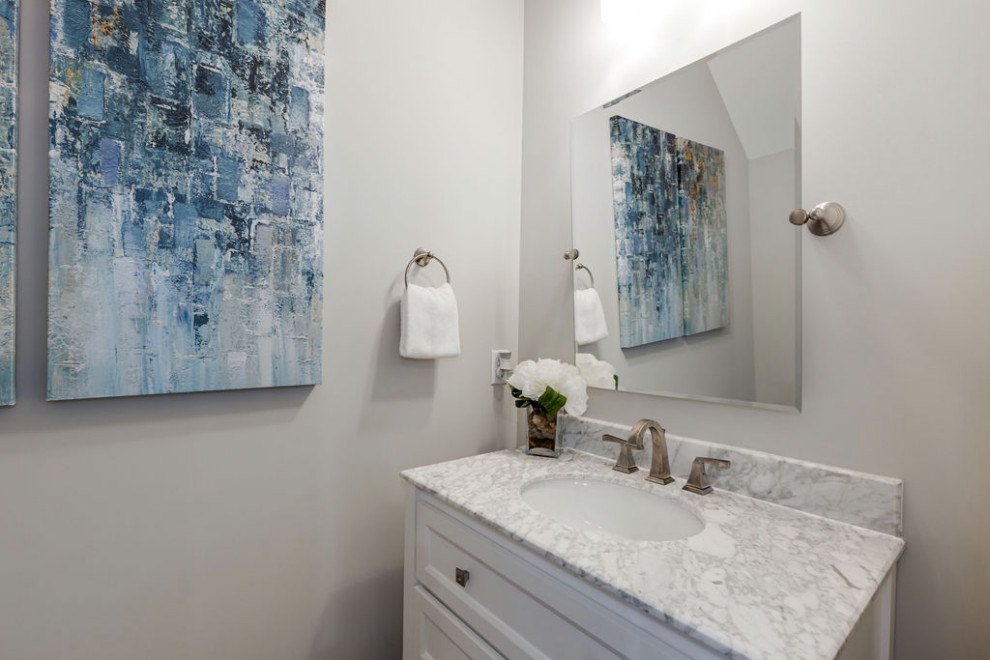 Klassisk inredning av ett mellanstort grå grått badrum med dusch, med luckor med infälld panel, vita skåp, grå väggar, mellanmörkt trägolv, ett integrerad handfat, bänkskiva i akrylsten och brunt golv
