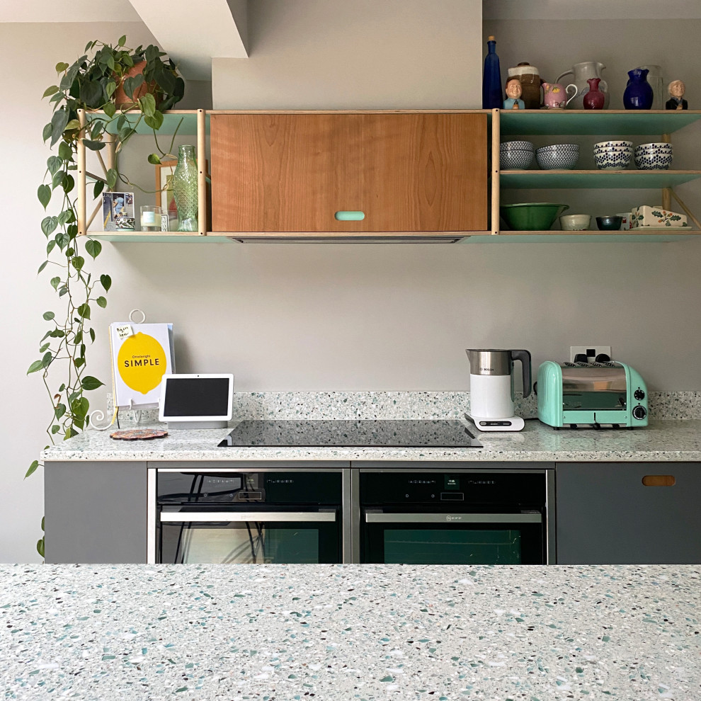Aménagement d'une cuisine moderne avec un plan de travail en verre recyclé et un plan de travail turquoise.