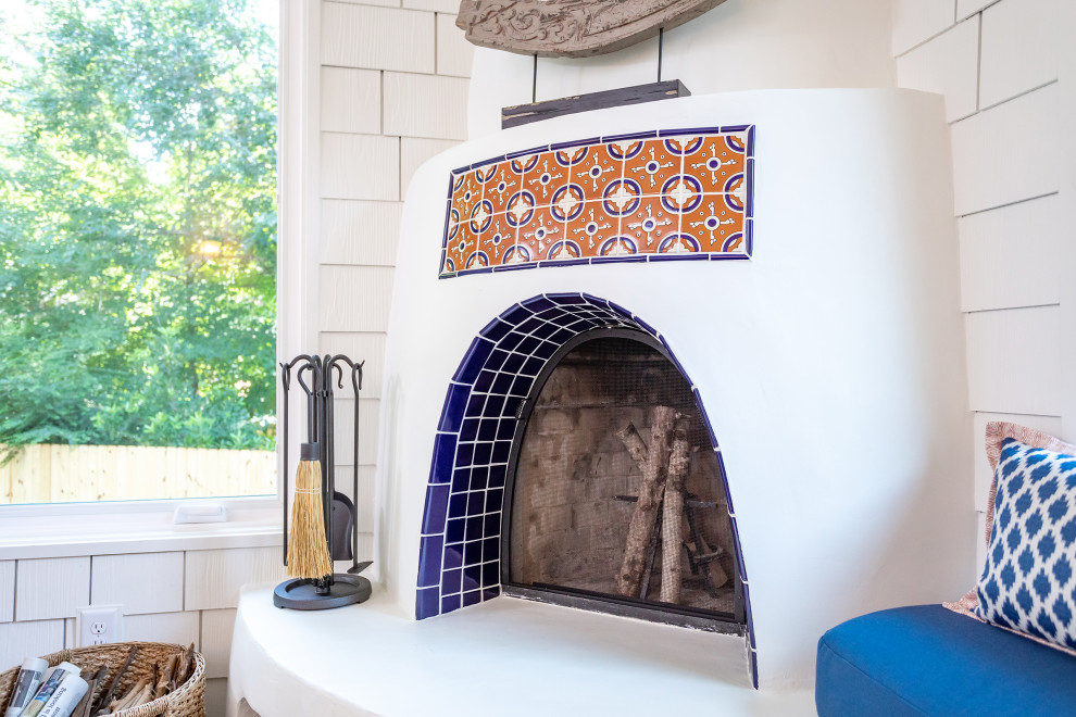 Cette photo montre une véranda sud-ouest américain de taille moyenne avec un sol en carrelage de porcelaine, une cheminée d'angle, un manteau de cheminée en plâtre et un sol marron.