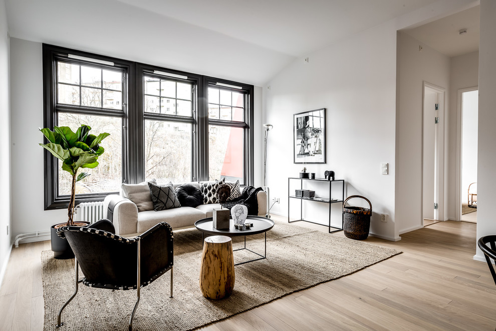 Photo of a large contemporary formal enclosed living room in Stockholm with white walls, light hardwood floors, brown floor, no fireplace and no tv.