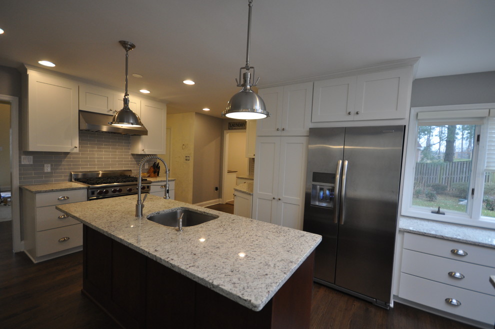 Example of a large transitional u-shaped dark wood floor and brown floor eat-in kitchen design in DC Metro with an island, an undermount sink, shaker cabinets, white cabinets, green backsplash, subway tile backsplash and stainless steel appliances