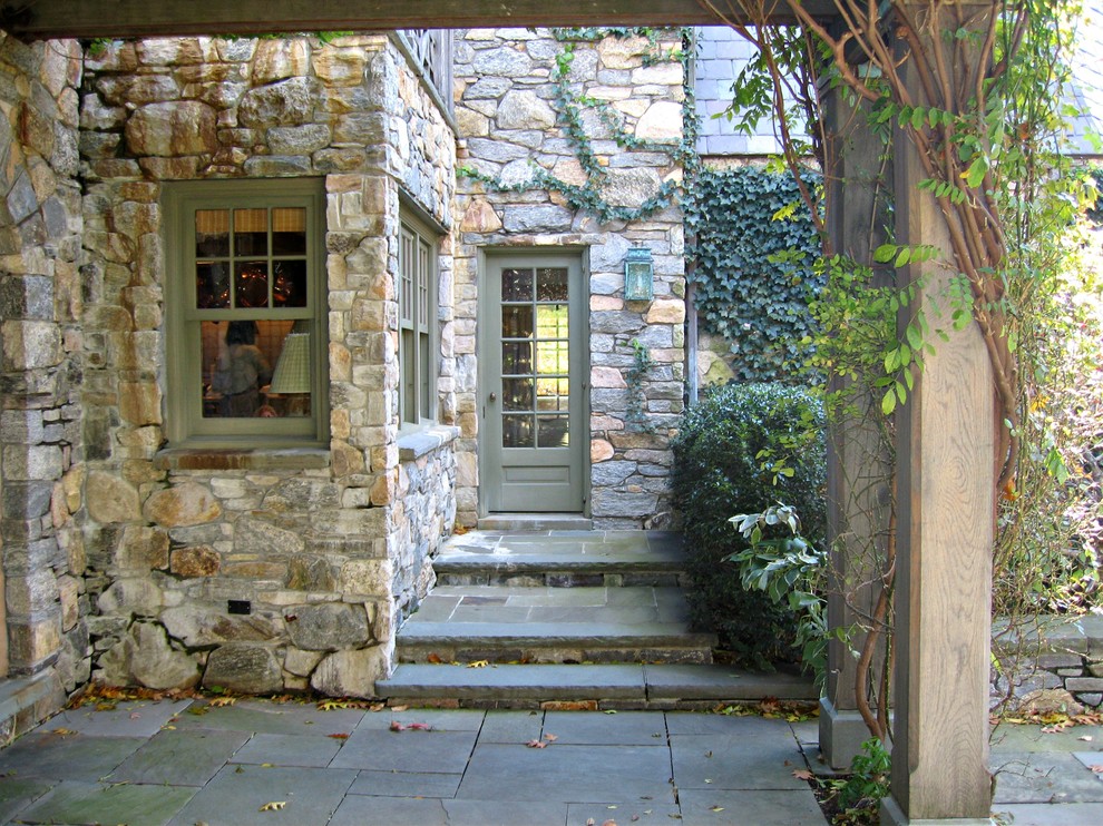 This is an example of an expansive country front door in New York with green walls, a double front door and a medium wood front door.
