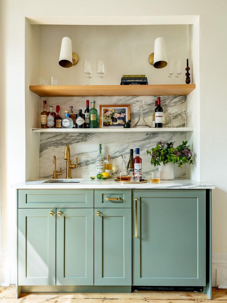 Photo of a small traditional galley wet bar in New York with a submerged sink, shaker cabinets, green cabinets, marble worktops, multi-coloured splashback, marble splashback, medium hardwood flooring and white worktops.