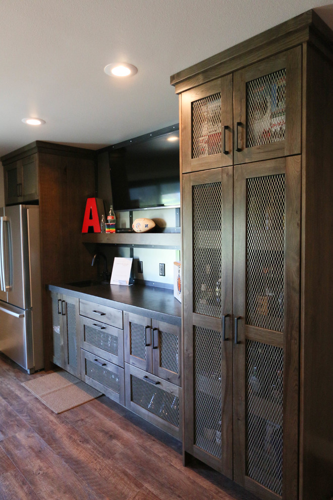 Photo of a mid-sized industrial single-wall seated home bar in Other with an undermount sink, dark wood cabinets, granite benchtops, grey splashback, vinyl floors and shaker cabinets.