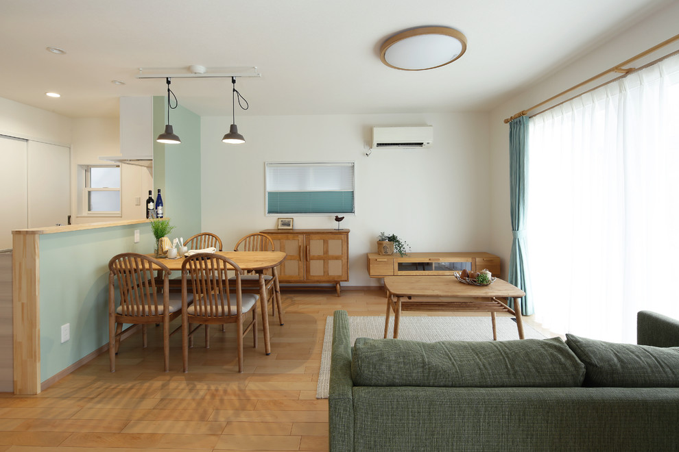 Asian dining room in Other with white walls, beige floor and light hardwood floors.