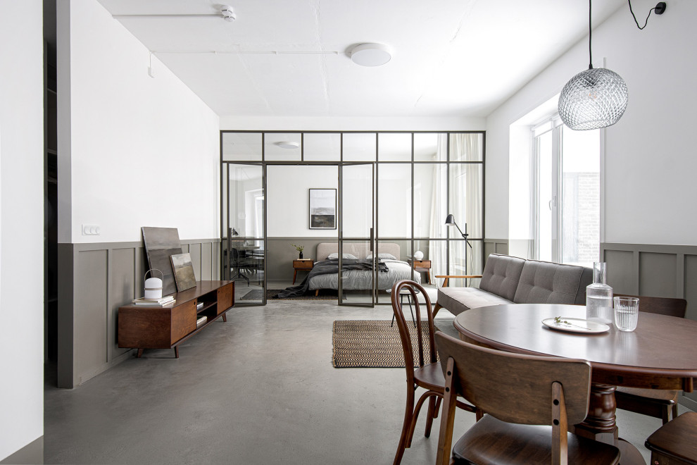 Foto di un soggiorno contemporaneo di medie dimensioni e aperto con pareti bianche, pavimento in cemento, pavimento grigio e pannellatura