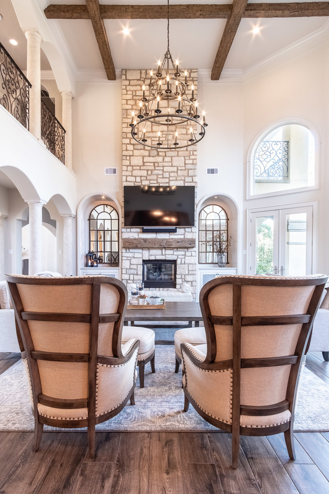 Large open concept family room in Houston with porcelain floors, a two-sided fireplace, a stone fireplace surround, a wall-mounted tv and brown floor.