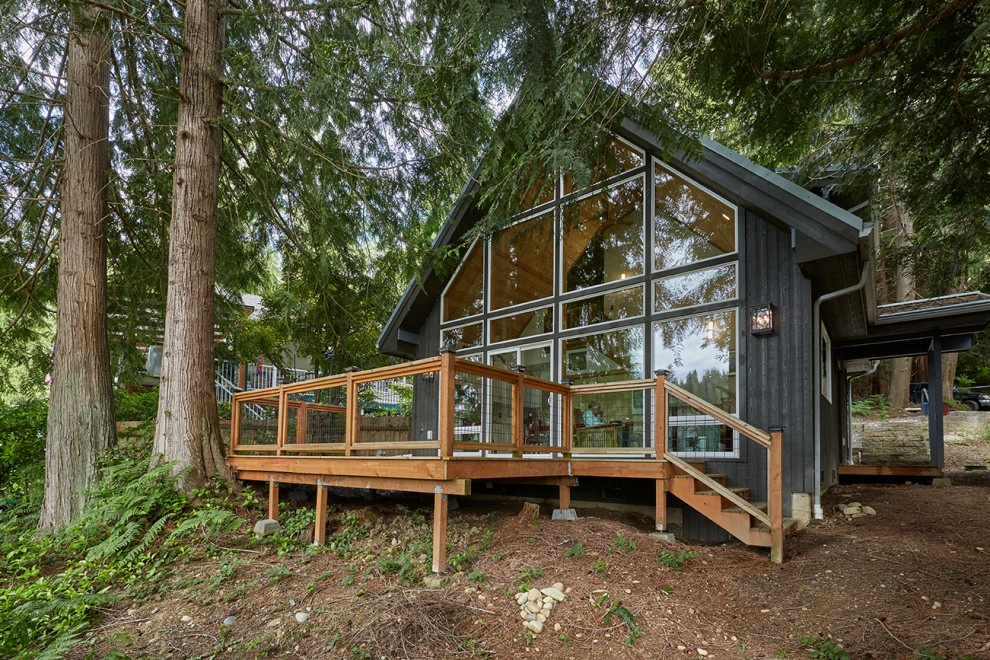 Kleines, Zweistöckiges Uriges Haus mit schwarzer Fassadenfarbe, Satteldach, Blechdach und grauem Dach in Seattle