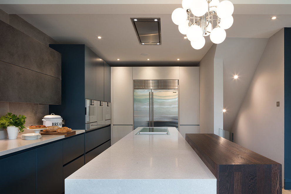 This is an example of a mid-sized contemporary single-wall eat-in kitchen in London with flat-panel cabinets, blue cabinets, solid surface benchtops, grey splashback, light hardwood floors, with island, beige floor and white benchtop.