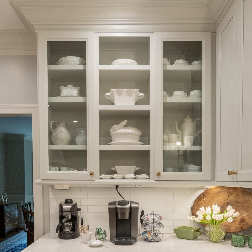 Example of a mid-sized transitional galley medium tone wood floor and brown floor kitchen pantry design with an undermount sink, shaker cabinets, gray cabinets, granite countertops, white backsplash, ceramic backsplash, stainless steel appliances, no island and white countertops