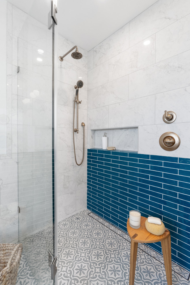 Идея дизайна: главная ванная комната среднего размера в стиле неоклассика (современная классика) с фасадами островного типа, синими фасадами, накладной ванной, угловым душем, биде, синей плиткой, керамической плиткой, белыми стенами, полом из мозаичной плитки, врезной раковиной, мраморной столешницей, серым полом, душем с распашными дверями, белой столешницей, тумбой под две раковины, встроенной тумбой и кессонным потолком