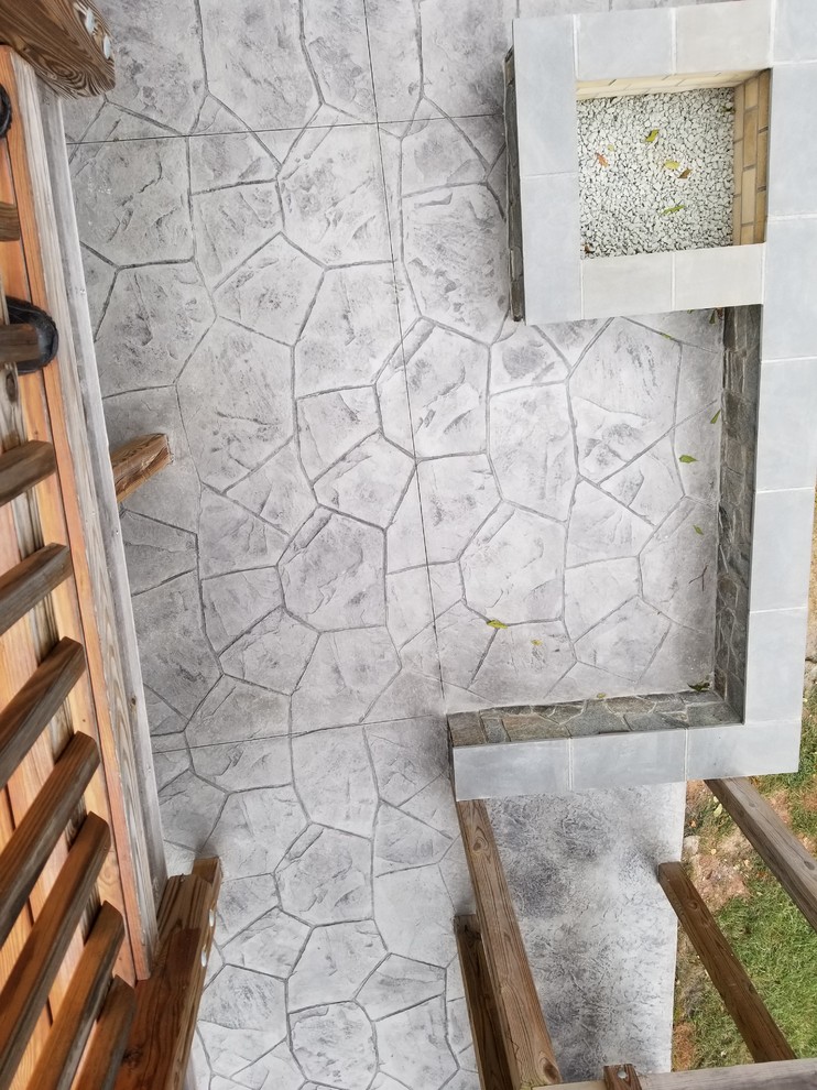 This is an example of a large tropical backyard patio in Other with stamped concrete.