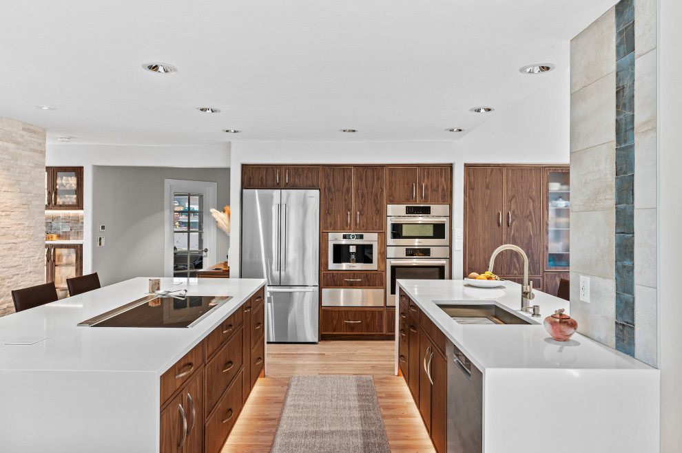 Inspiration for a large contemporary galley eat-in kitchen in Denver with an undermount sink, flat-panel cabinets, medium wood cabinets, quartz benchtops, blue splashback, porcelain splashback, stainless steel appliances, light hardwood floors, multiple islands, brown floor, white benchtop and vaulted.