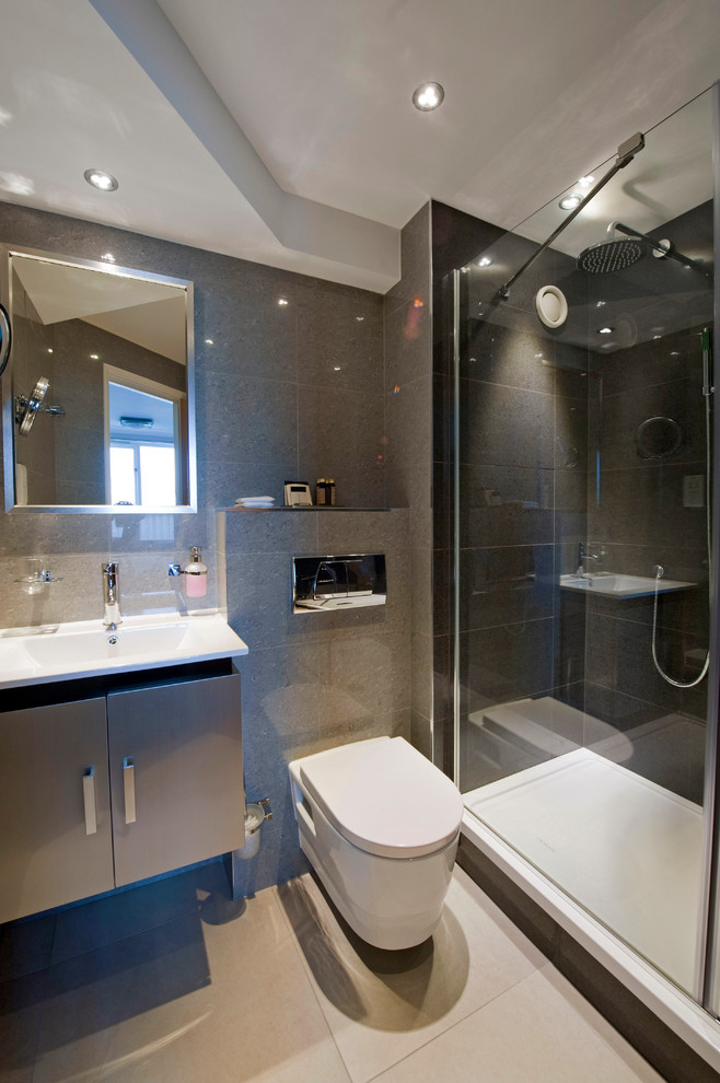 Inspiration for a small contemporary master bathroom in London with flat-panel cabinets, brown cabinets, an alcove shower, a wall-mount toilet, ceramic tile, grey walls, mosaic tile floors, solid surface benchtops, an alcove tub, beige tile, a trough sink, beige floor and a hinged shower door.