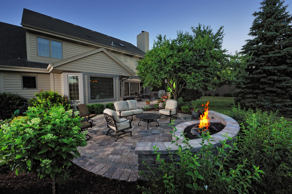 Design ideas for a mid-sized traditional backyard patio in Milwaukee with concrete pavers, no cover and a fire feature.