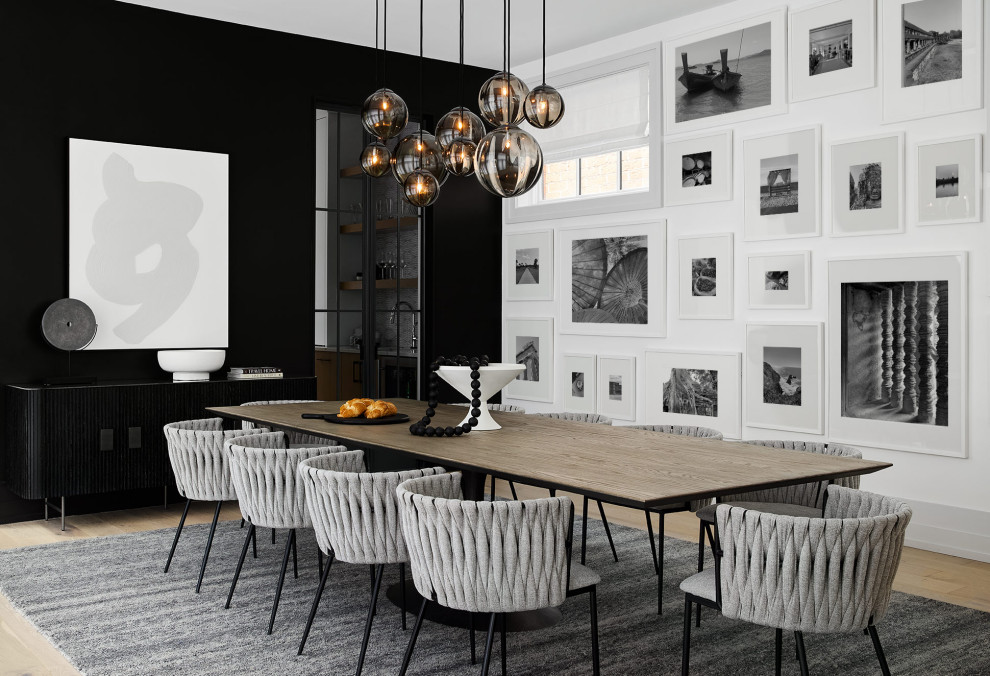 Photo of a contemporary dining room in Chicago with black walls, light hardwood floors and no fireplace.
