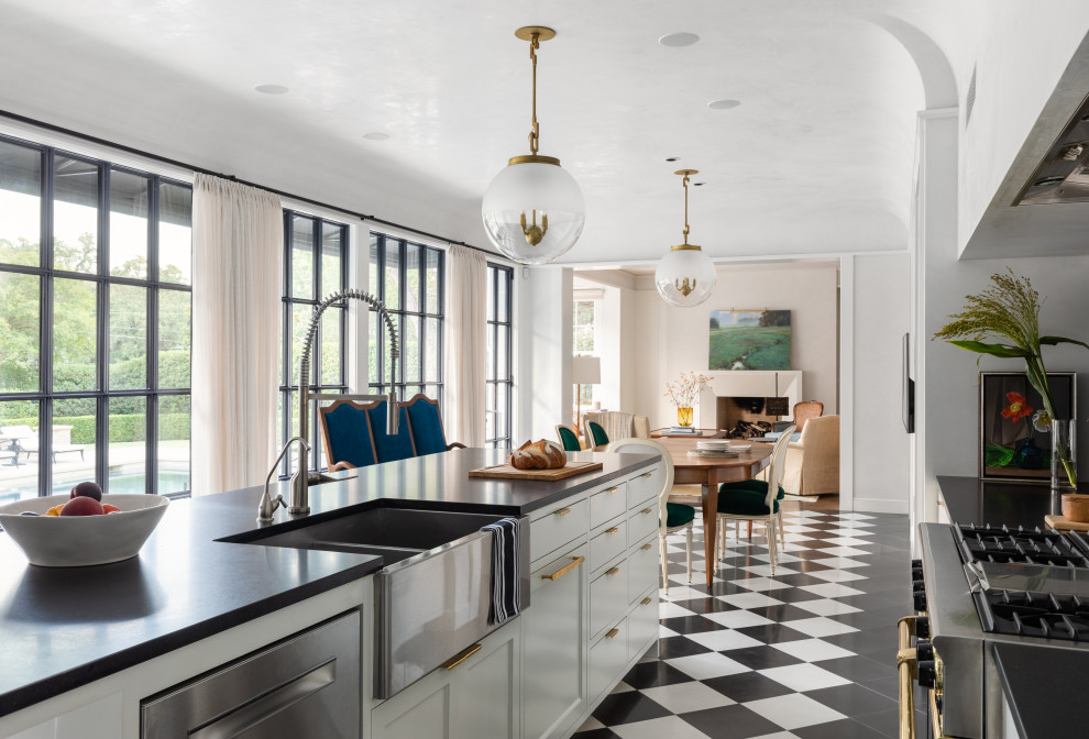 Design ideas for a large mediterranean galley eat-in kitchen in Austin with a farmhouse sink, recessed-panel cabinets, white cabinets, stainless steel appliances, porcelain floors, with island, multi-coloured floor and black benchtop.