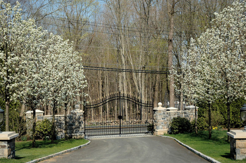 This is an example of a mid-sized traditional front yard driveway in New York with natural stone pavers.