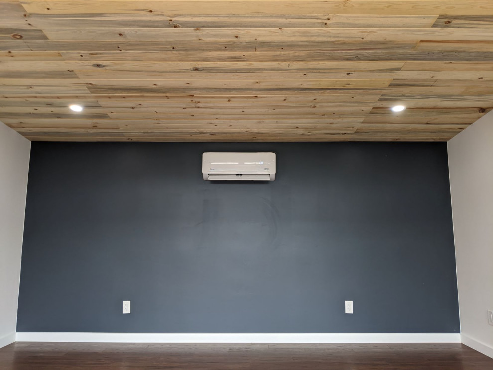 На фото: домашняя мастерская среднего размера с черными стенами, темным паркетным полом, коричневым полом и деревянным потолком