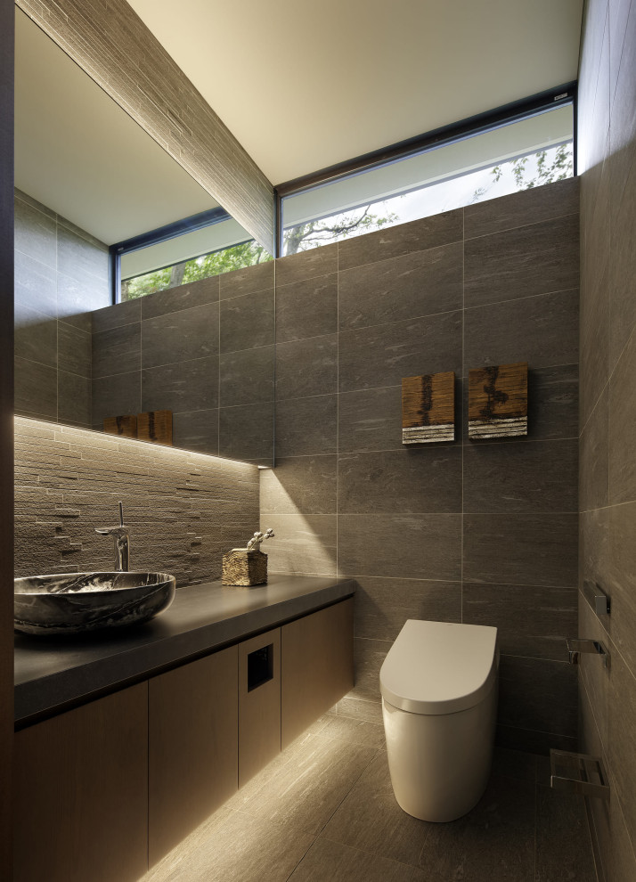 Idee per un bagno di servizio moderno con ante lisce, ante in legno bruno, lavabo a bacinella, pavimento grigio, top grigio e mobile bagno sospeso