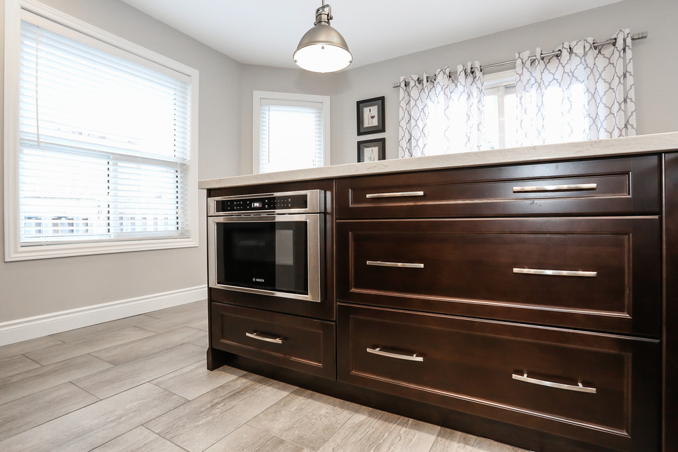 Enclosed kitchen - mid-sized transitional l-shaped porcelain tile enclosed kitchen idea in Toronto with an undermount sink, recessed-panel cabinets, dark wood cabinets, quartz countertops, gray backsplash, mosaic tile backsplash, stainless steel appliances and an island
