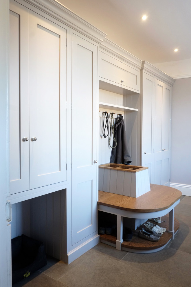 Inspiration for a small traditional single-wall laundry cupboard in Cambridgeshire with shaker cabinets, grey cabinets, wood benchtops, grey walls, limestone floors, beige floor and brown benchtop.