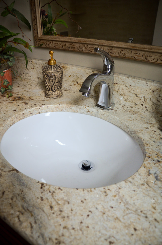 Traditional bathroom in Other with granite benchtops and an undermount sink.