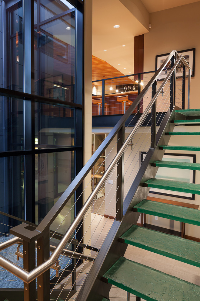 This is an example of a mid-sized contemporary glass u-shaped staircase in Seattle with open risers and cable railing.