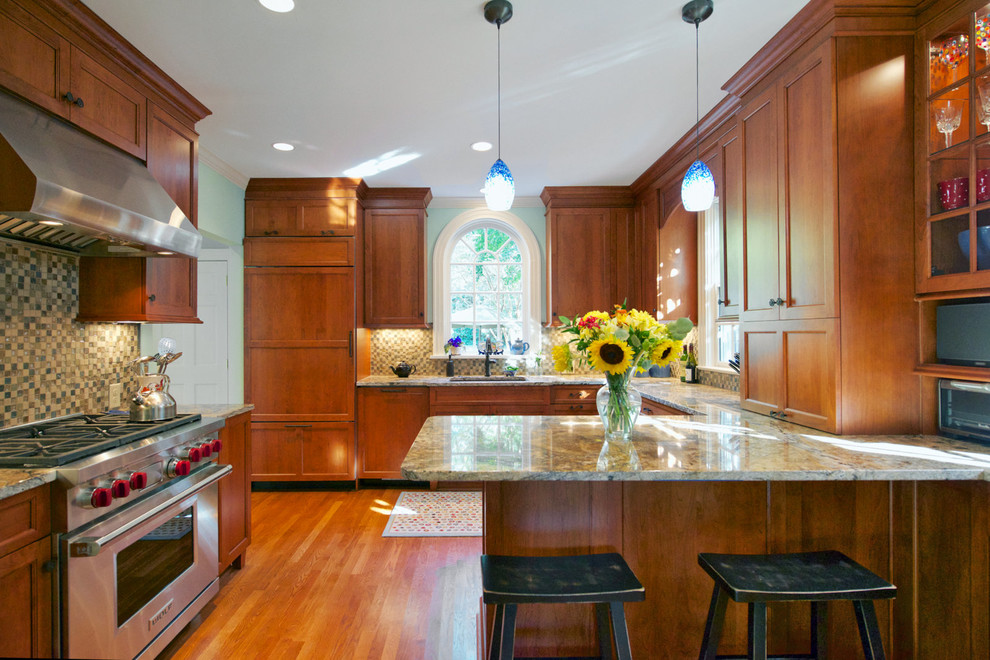 Mid-sized transitional u-shaped medium tone wood floor enclosed kitchen photo with recessed-panel cabinets, medium tone wood cabinets, mosaic tile backsplash, paneled appliances, an undermount sink, granite countertops, multicolored backsplash and a peninsula