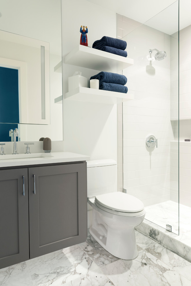 Design ideas for a small contemporary kids wet room bathroom in Dallas with shaker cabinets, grey cabinets, a one-piece toilet, white tile, subway tile, white walls, marble floors, an undermount sink, engineered quartz benchtops, white floor, a hinged shower door and white benchtops.