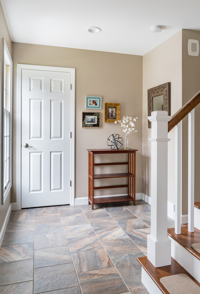 Example of a mid-sized transitional porcelain tile foyer design in Grand Rapids with beige walls