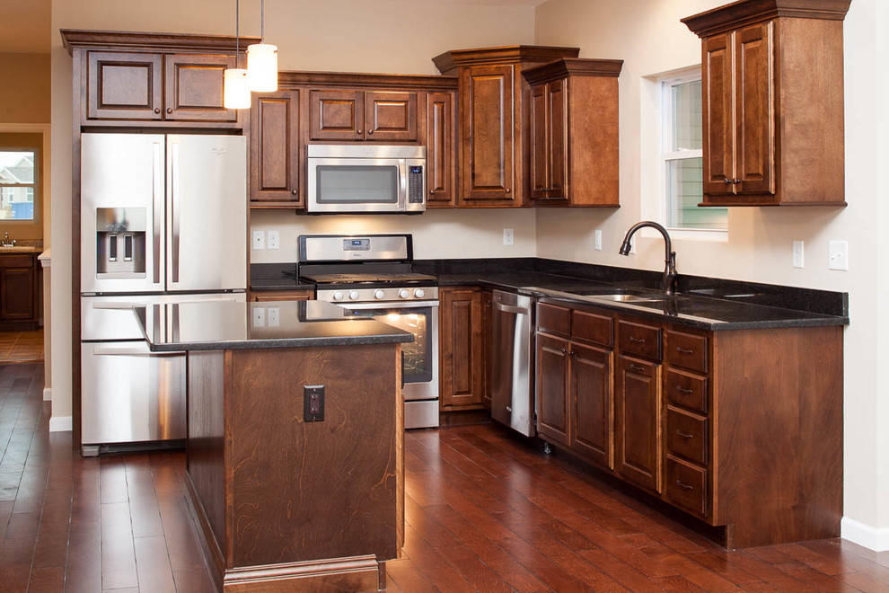 Inspiration for a transitional dark wood floor eat-in kitchen remodel in Chicago with a double-bowl sink, dark wood cabinets, granite countertops, stainless steel appliances and an island