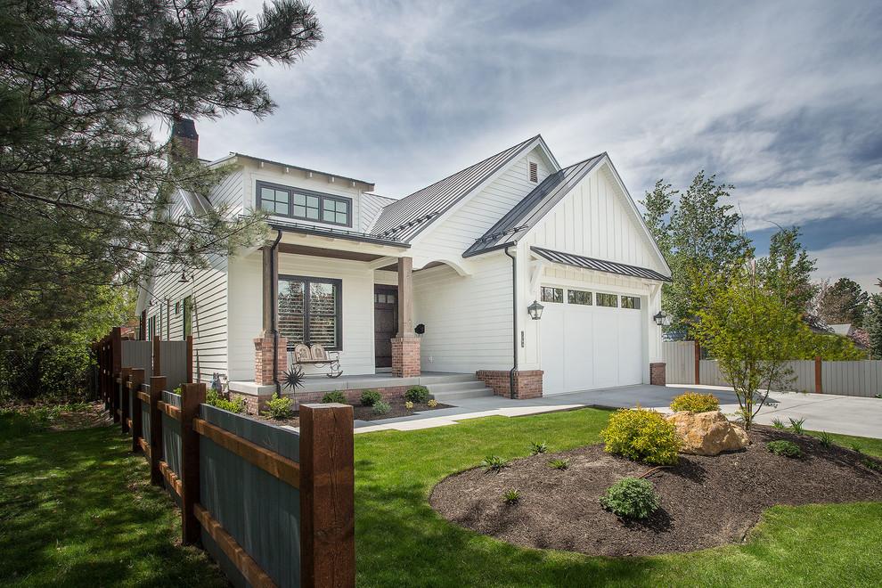 Mid-sized country two-storey white house exterior in Salt Lake City with vinyl siding, a gable roof and a metal roof.