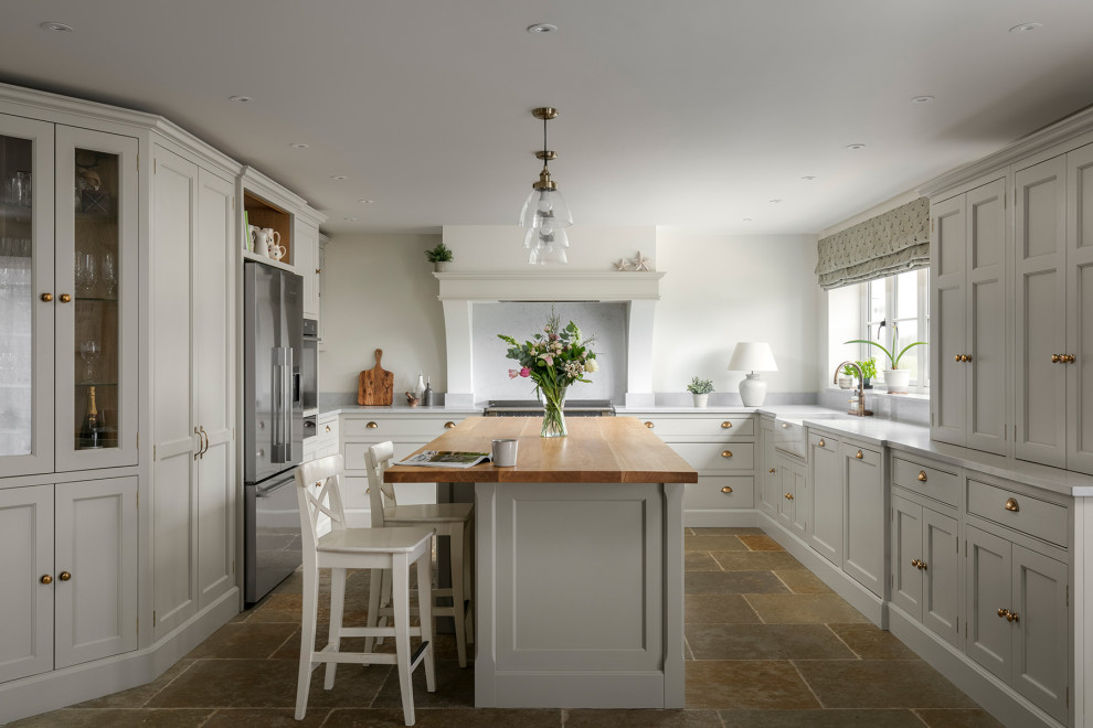 Inspiration for a country u-shaped kitchen/diner in Other with recessed-panel cabinets, beige cabinets, quartz worktops, stainless steel appliances, slate flooring, an island, beige worktops and a chimney breast.