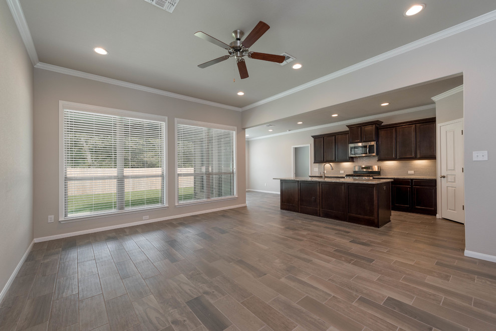 Photo of a mid-sized arts and crafts open concept family room in Austin with beige walls, laminate floors, no tv, multi-coloured floor and no fireplace.