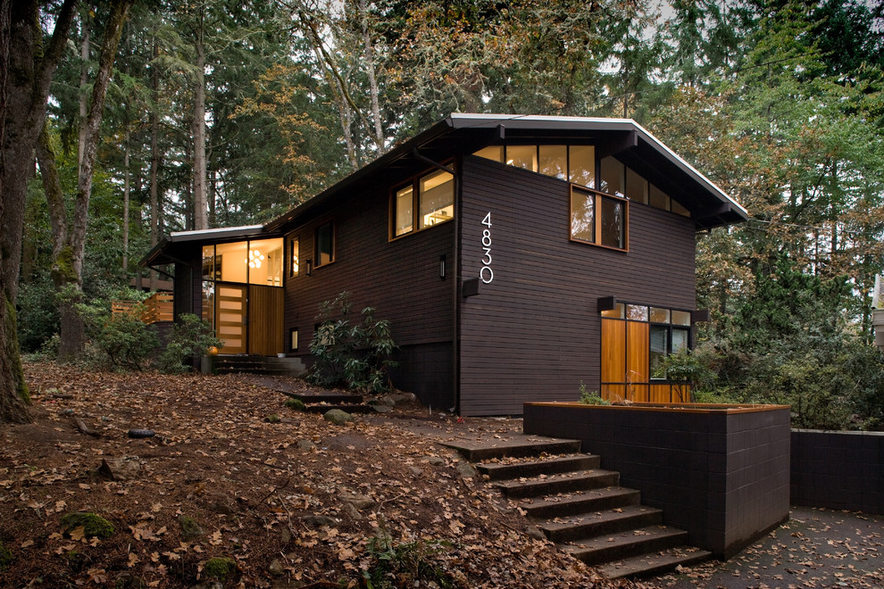 This is an example of a midcentury exterior in Portland with wood siding and a gable roof.