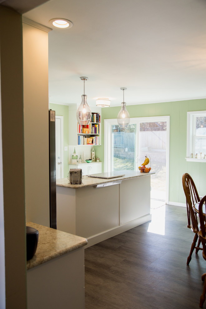 This is an example of a small transitional l-shaped open plan kitchen in Denver with an integrated sink, recessed-panel cabinets, white cabinets, laminate benchtops, green splashback, glass tile splashback, stainless steel appliances, linoleum floors and with island.
