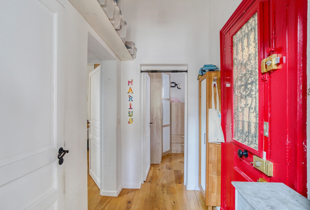 Inspiration för en mellanstor funkis hall, med vita väggar, ljust trägolv, en enkeldörr, en röd dörr och brunt golv